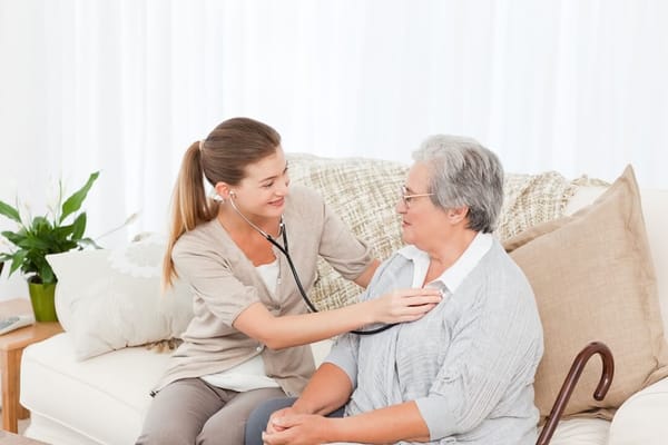 A caregiver using a stethoscope with a resident