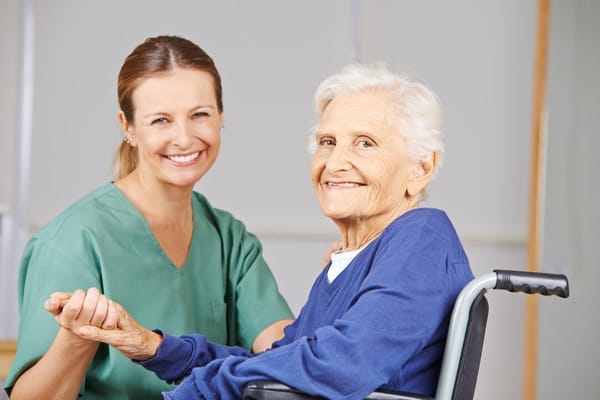 Caregiver assisting a senior resident in a friendly environment
