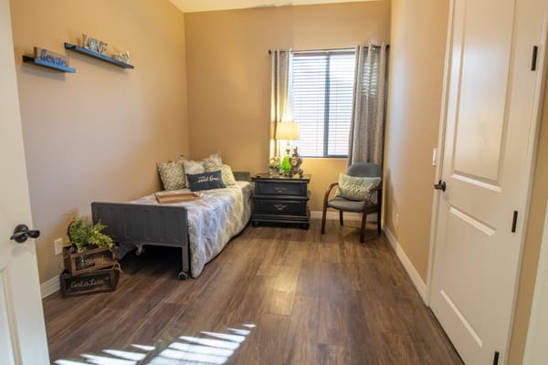 Cozy interior of a resident room with bed and chair
