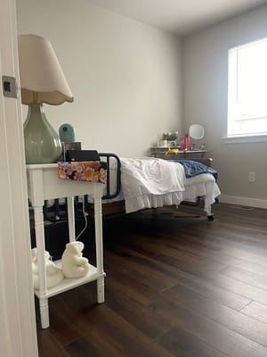 Private resident room with a bed and bedside table