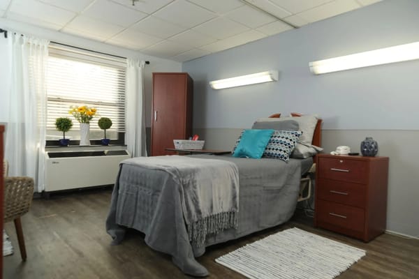 Brightly decorated resident room with a bed and furnishings