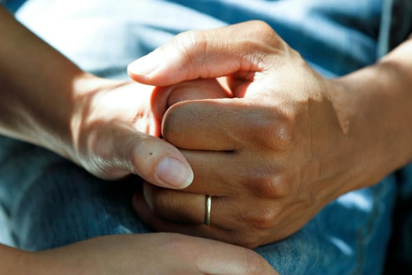 Two hands holding each other in a caring gesture