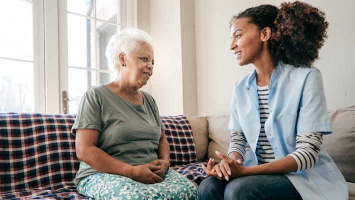 Caregiver conversing with a senior resident in an indoor setting