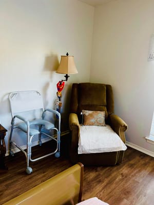 Cozy resident room with a recliner and lamp