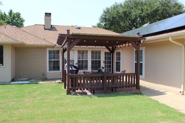 Outdoor seating area with pergola and grass