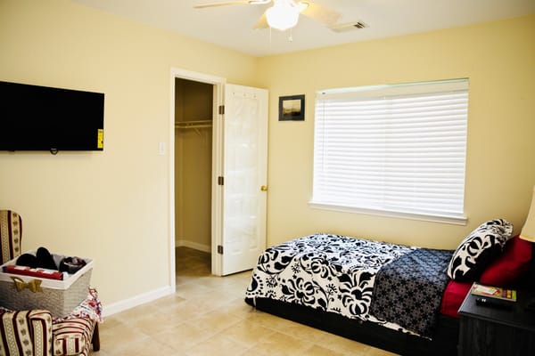 A cozy resident room with bed and chair