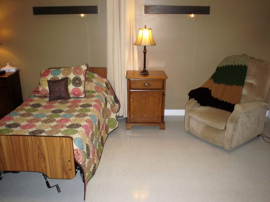 A private resident room with a bed and chair