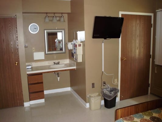 Interior view of a resident's room with a bed and television