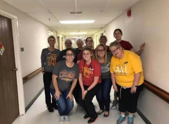 Staff and residents posing together in a hallway