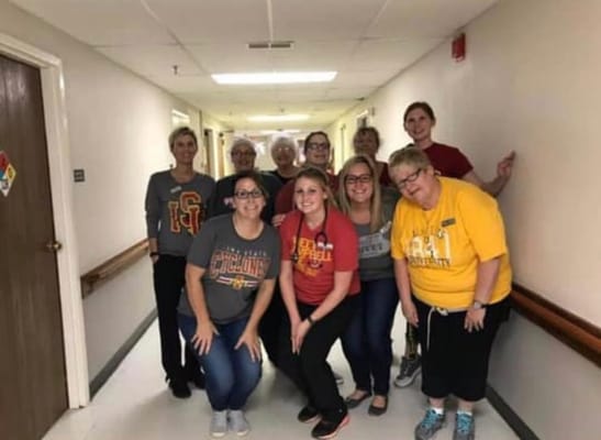 Staff and residents posing together in a hallway