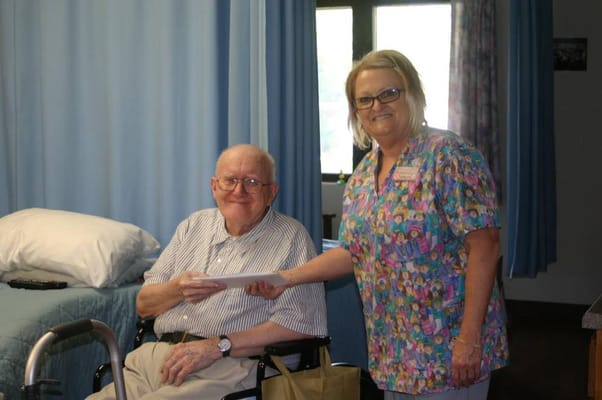 Staff member handing an envelope to a smiling resident
