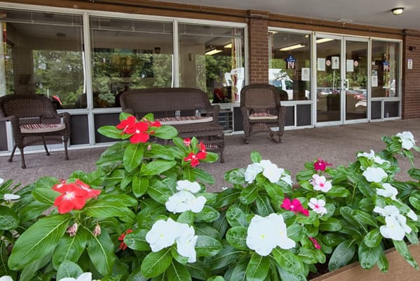 Welcoming entrance with flower beds and seating area