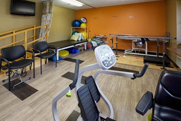A rehabilitation room with exercise equipment and therapy tools