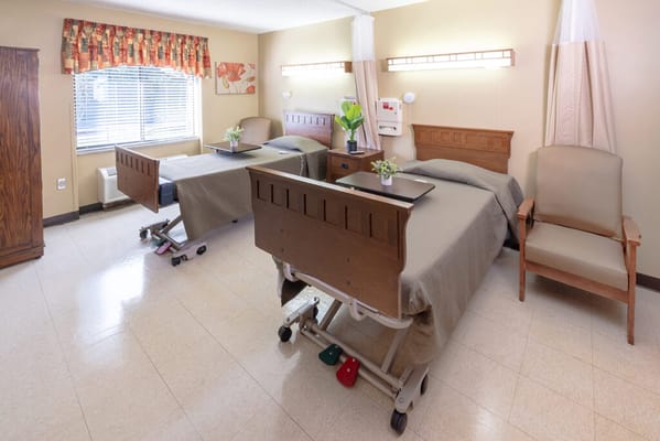 A cozy resident room with two beds and natural light