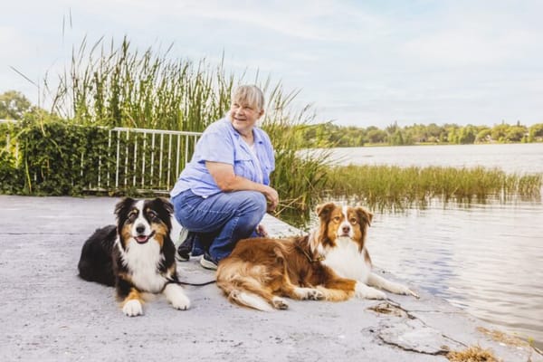 Resident enjoying time outdoors with two dogs by the water