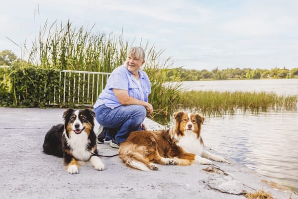 Resident enjoying time outdoors with two dogs by the water