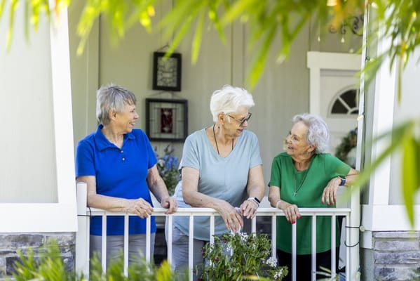 Three senior women chatting on a porch