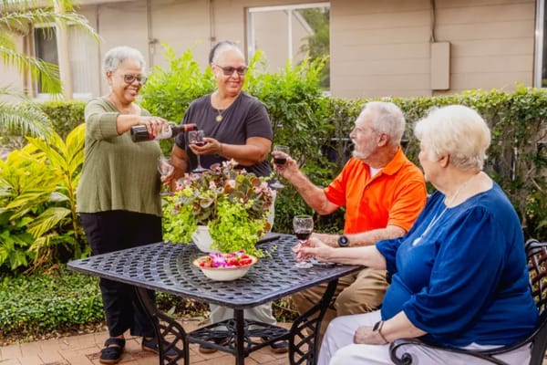 Residents enjoying drinks together in a garden setting