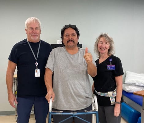 Staff and resident posing together in therapy room