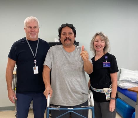Staff and resident posing together in therapy room