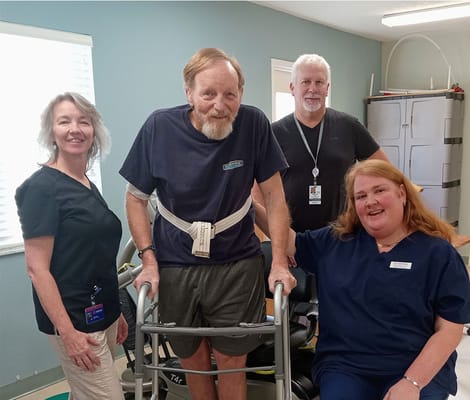 Staff assisting a resident in a therapy setting