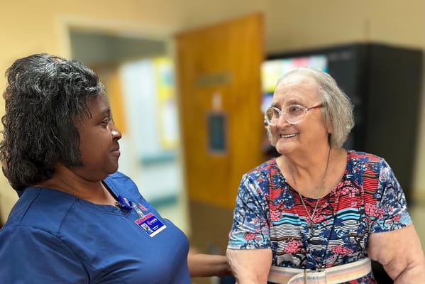 Staff member interacting with a smiling resident