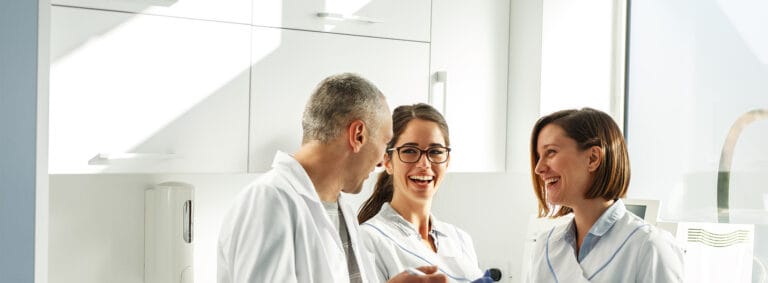 Three staff members smiling in a facility setting