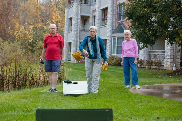 Residents enjoying a game of cornhole outside