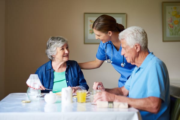 Residents enjoying a meal with attentive staff