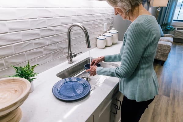 Resident washing dishes in a modern kitchen