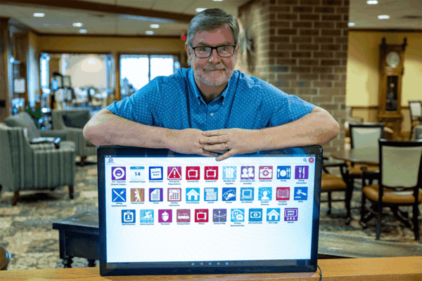 Staff member presenting a digital display in a lounge area