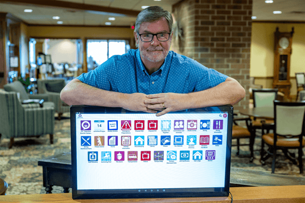 Staff member presenting a digital display in a lounge area