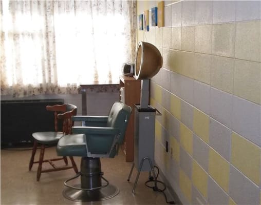 A salon area with a hairdryer and chairs