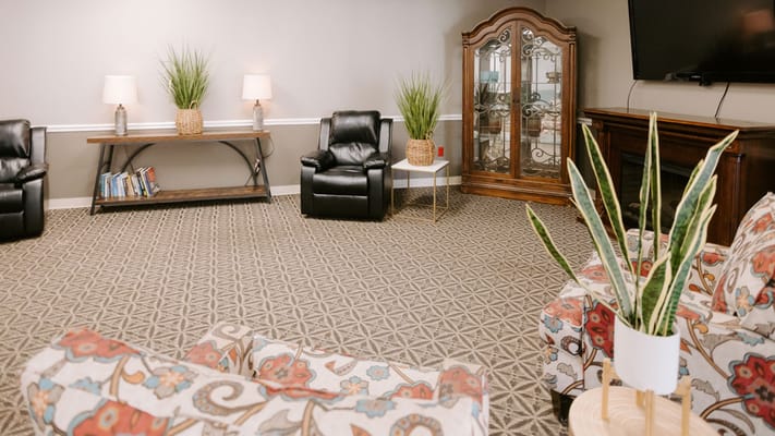Cozy common area with chairs and a decorative cabinet