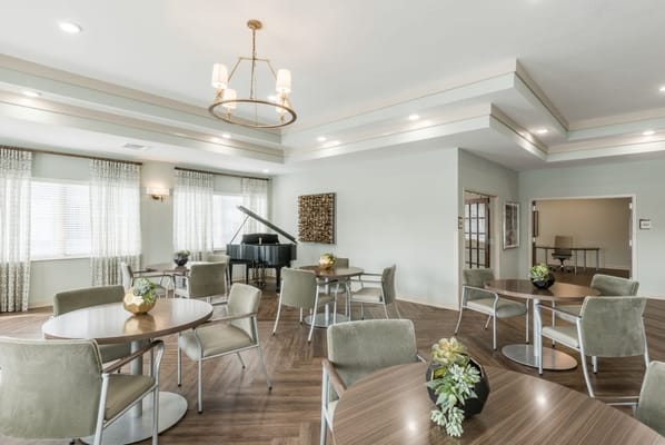 Bright common area with tables and a piano