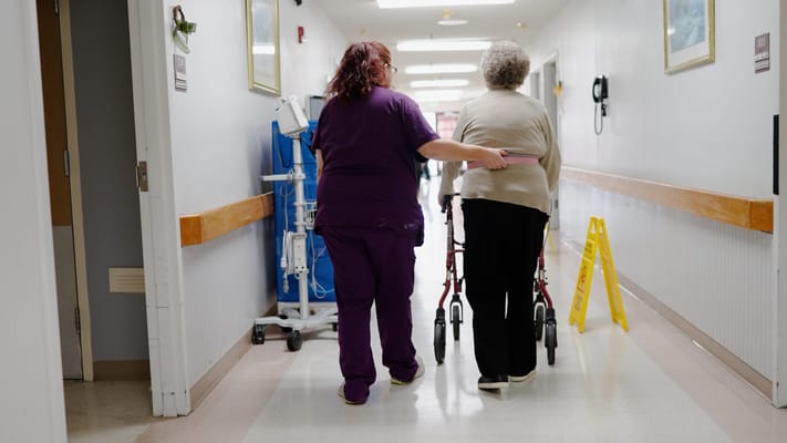 Care staff assisting a resident in the hallway