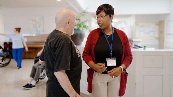 Staff member talking with a resident in a communal area
