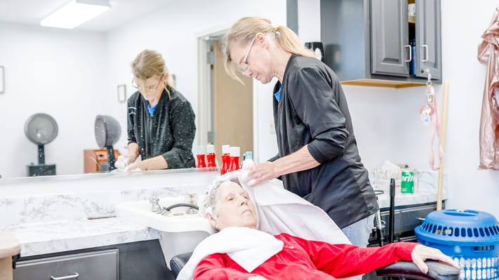 Stylist giving a hair treatment to a resident in the salon