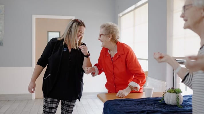 Residents and staff laughing together in a common area