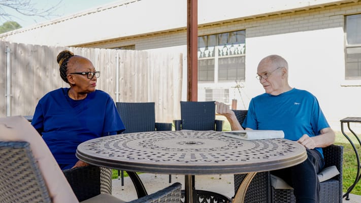 Two residents enjoying conversation outdoors