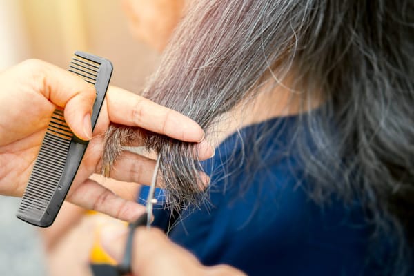 A resident receiving a haircut with a stylist