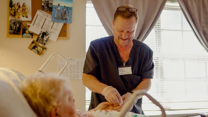 Staff assisting a resident in a bright room