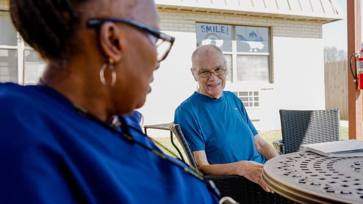 Residents enjoying conversation outdoors in a sunny area