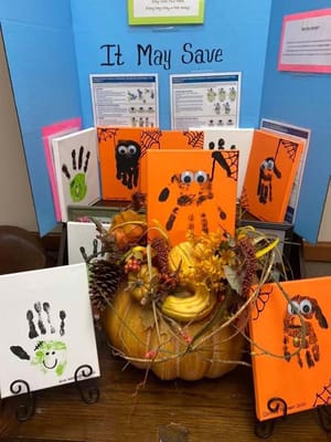 Decorative display of handprint art and pumpkins