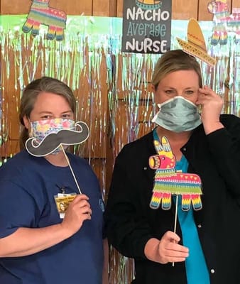 Two staff members with party props in an activity room
