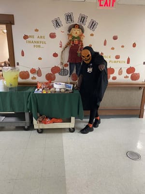 Staff member in a Halloween costume with treats