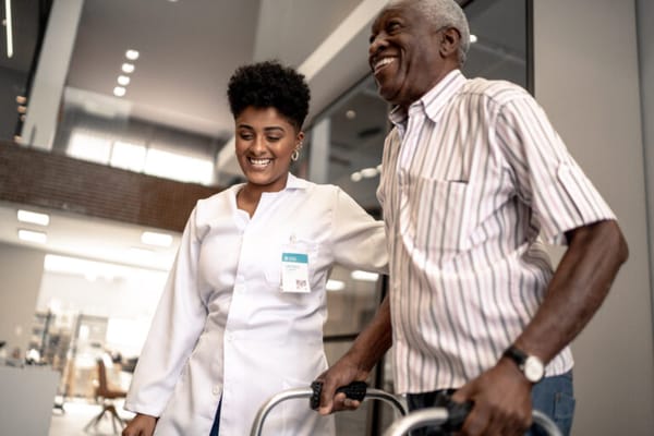 Staff assisting a resident in a bright facility interior