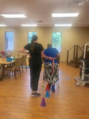 Staff assisting a resident in an activity room