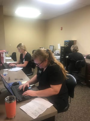 Staff members working at desks in an office setting