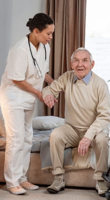 Healthcare professional assisting an elderly man in living room